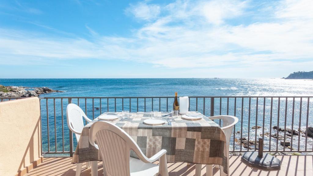 una mesa y sillas en un balcón con vistas al océano en Voramar B en Calella de Palafrugell