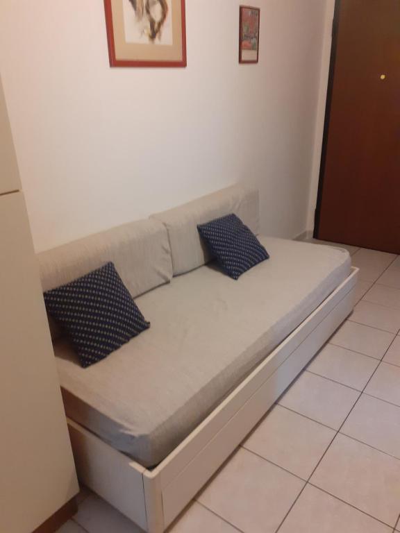 a bed in a room with two pillows on it at condominio guanabara in Lido di Jesolo