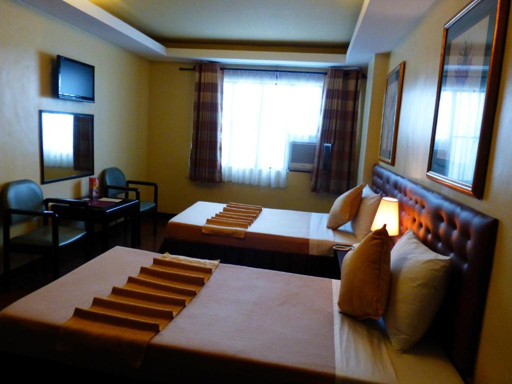 Postel nebo postele na pokoji v ubytování Silver Oaks Suites & Hotel