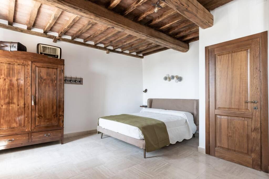 a bedroom with a bed and a wooden cabinet at Il Mercato - Appartamento con vista in Sinalunga
