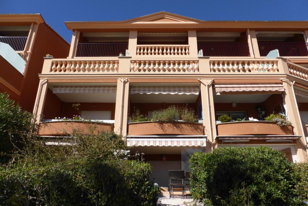 an apartment building with balconies and plants on it at Plage de Miramar in Théoule-sur-Mer