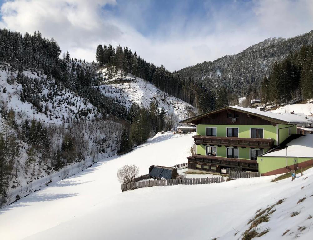 ein Gebäude im Schnee neben einem Berg in der Unterkunft Ferienwohnung Staltner in Schladming