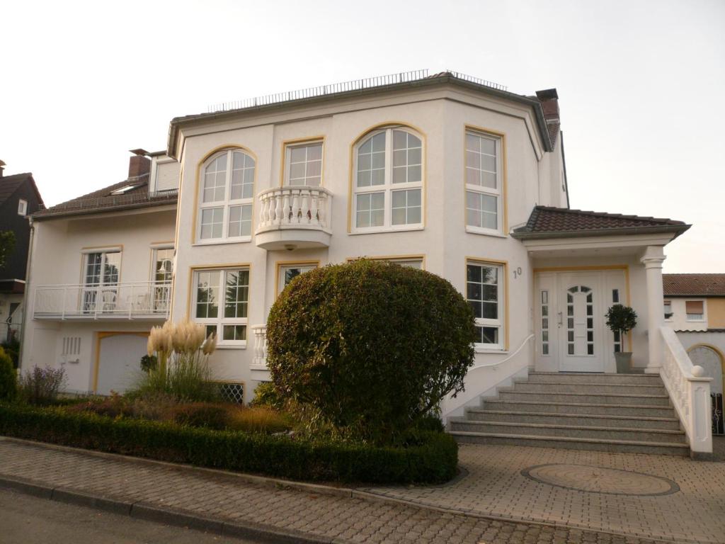 una casa blanca con una escalera delante en Ferienwohnungen Damm, en Kassel