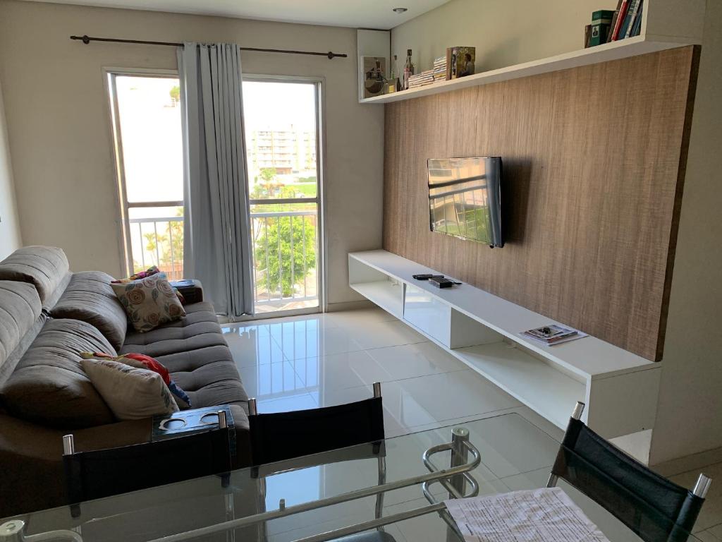 a living room with a couch and a glass table at Apartamento Decorado in Guarujá