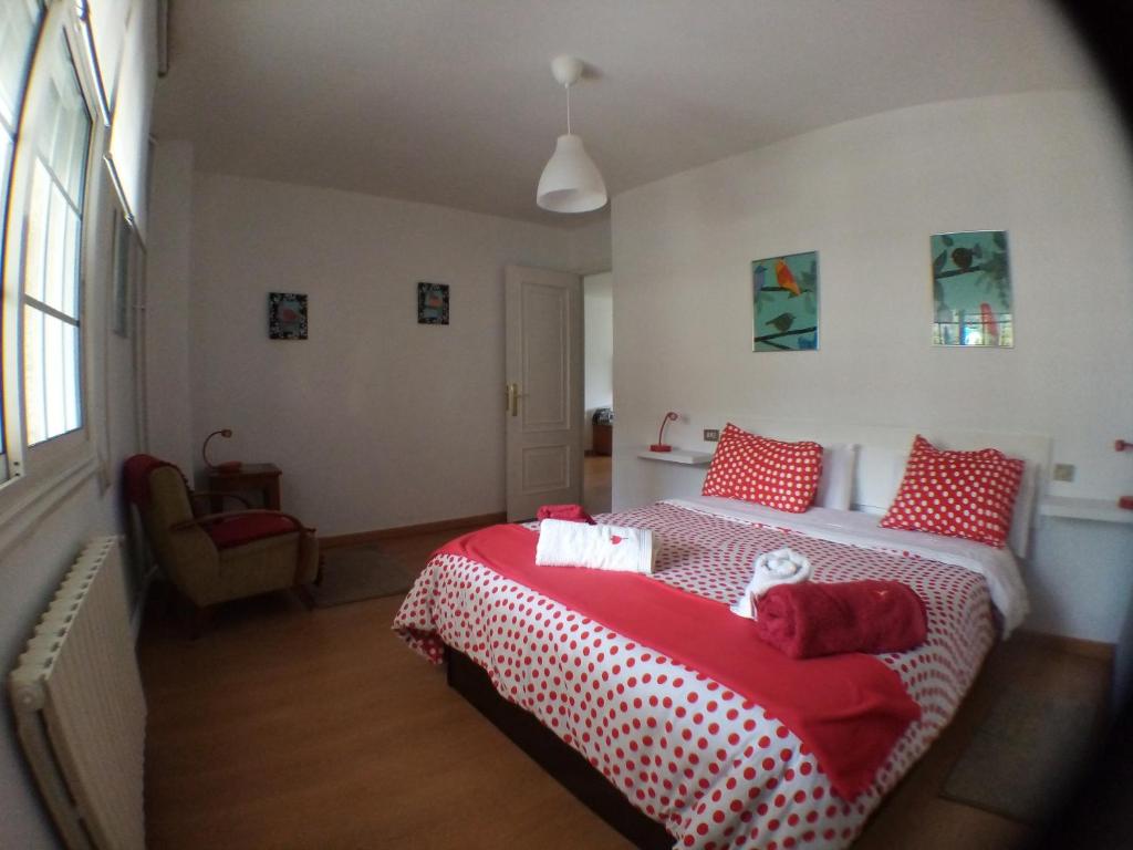 a bedroom with a bed with red and white sheets at Apartamento Tui, Casa da Barca in Tui