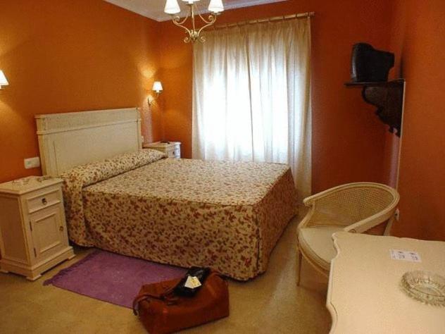 En eller flere senge i et værelse på Hostal Emilia