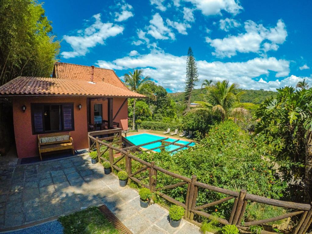 uma casa com uma piscina e uma cerca em Pousada Nova Gironda em Paty do Alferes