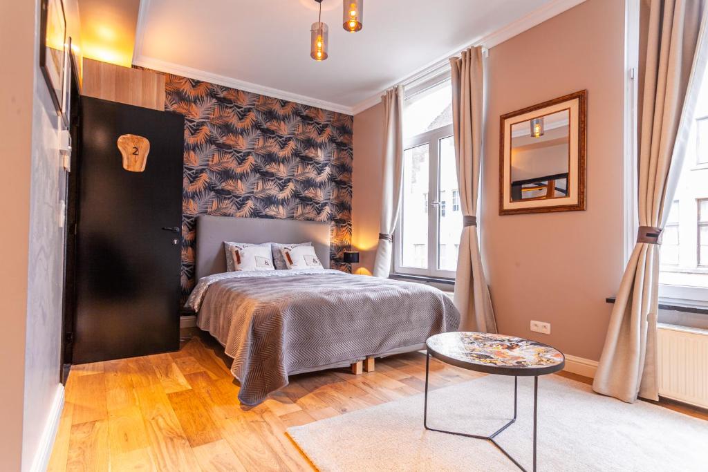 Schlafzimmer mit einem Bett und einem Tisch in der Unterkunft Luxury Suites Boutique in Antwerpen