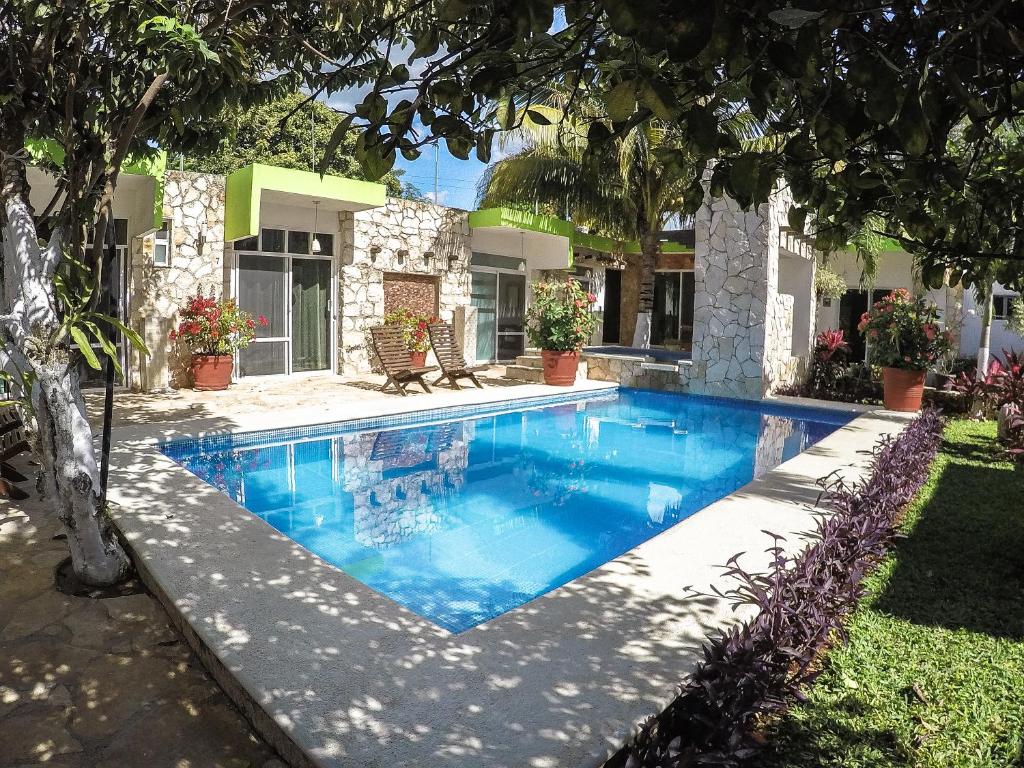 a swimming pool in front of a house at La Casa de las Lunas in Chichén-Itzá