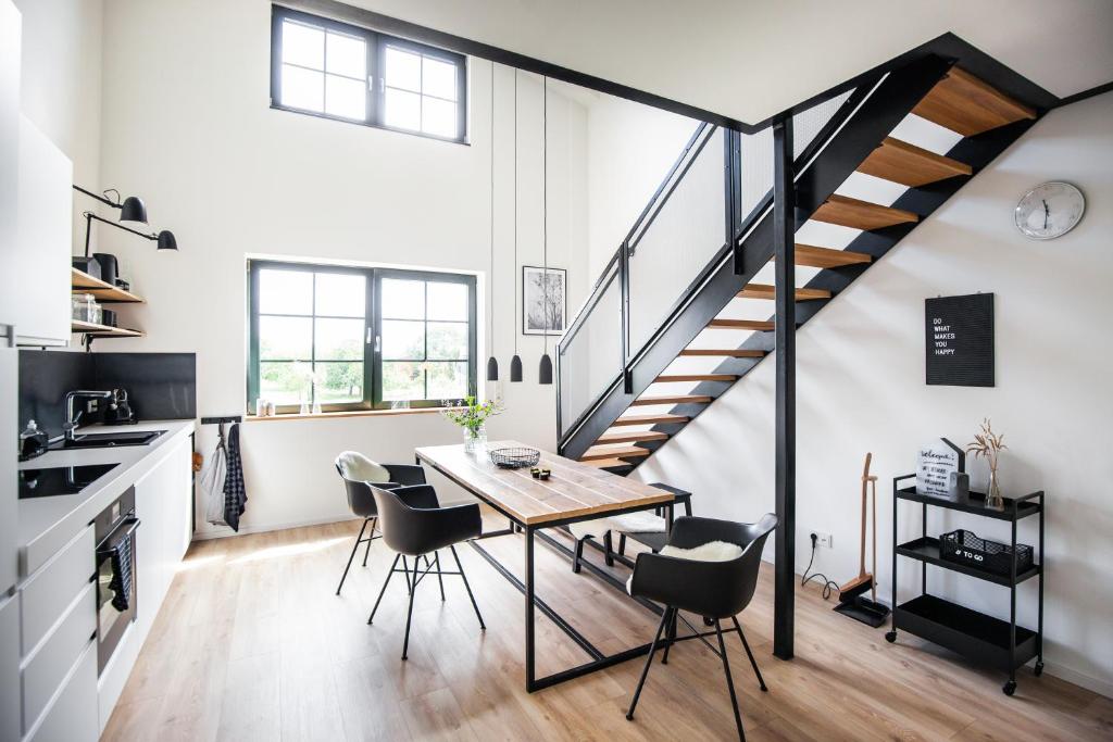 a kitchen and dining room with a table and a staircase at Apart Hüsske 1 in Krefeld