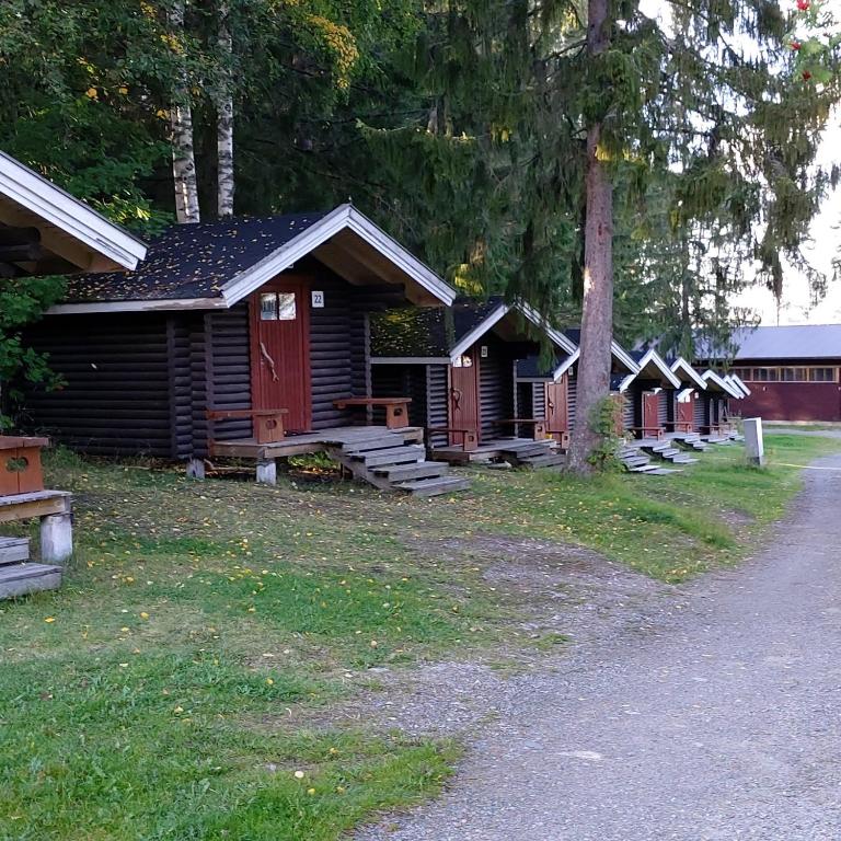 a row of wooden cabins sitting next to a road at Lomakylä Timitraniemi in Lieksa