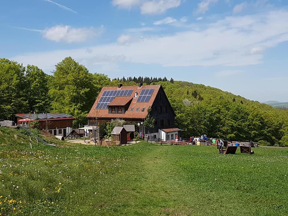 um celeiro com painéis solares no telhado num campo em Würzburger Haus em Geroda