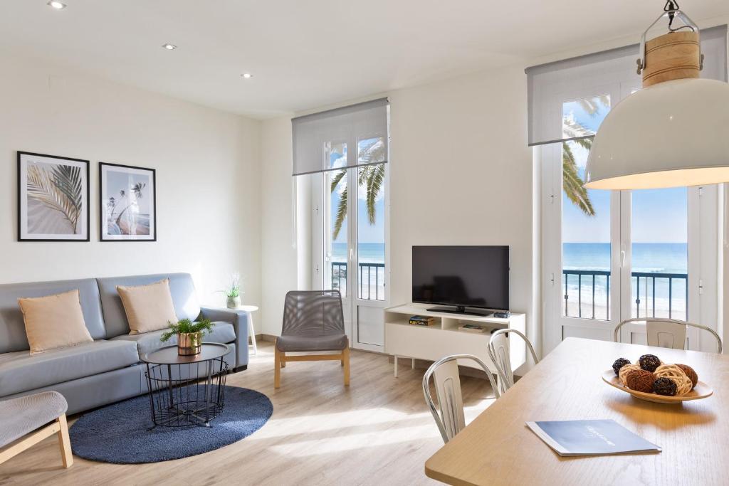 een woonkamer met een bank en een tafel bij Sitges Group Beach Dreams in Sitges
