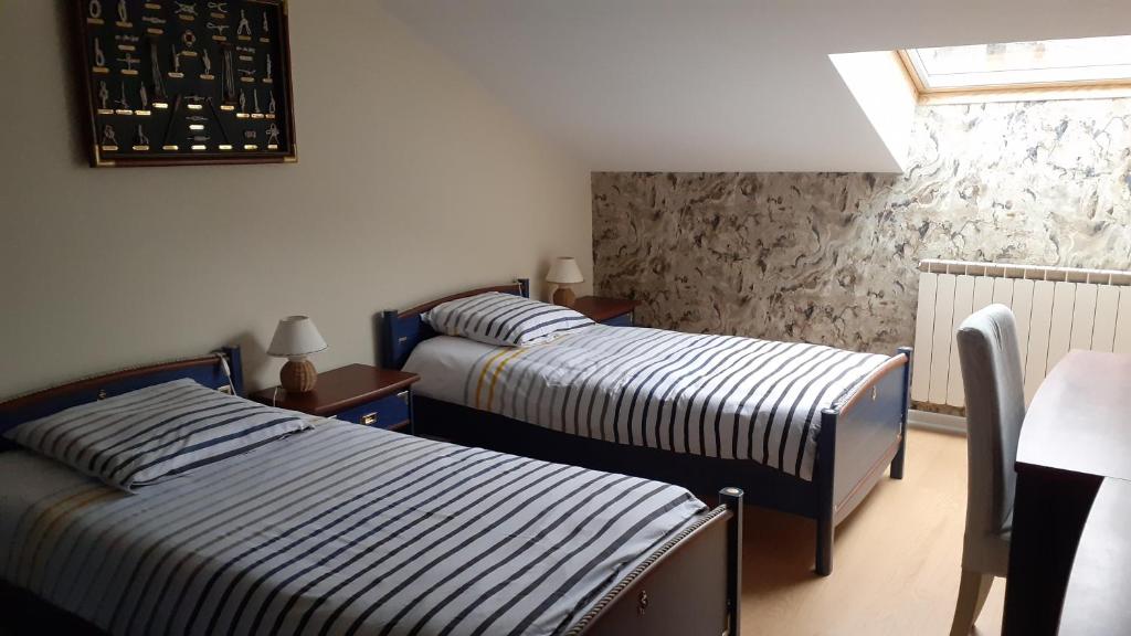 Zimmer mit 2 Betten, einem Tisch und einem Fenster in der Unterkunft gîte Les Coquelicots in Médière