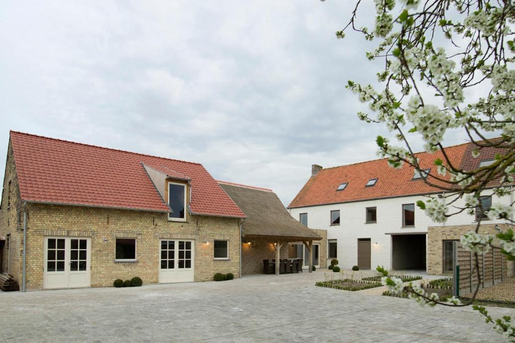 a group of three buildings with red roofs at Holiday Home De Maalderij in Diksmuide