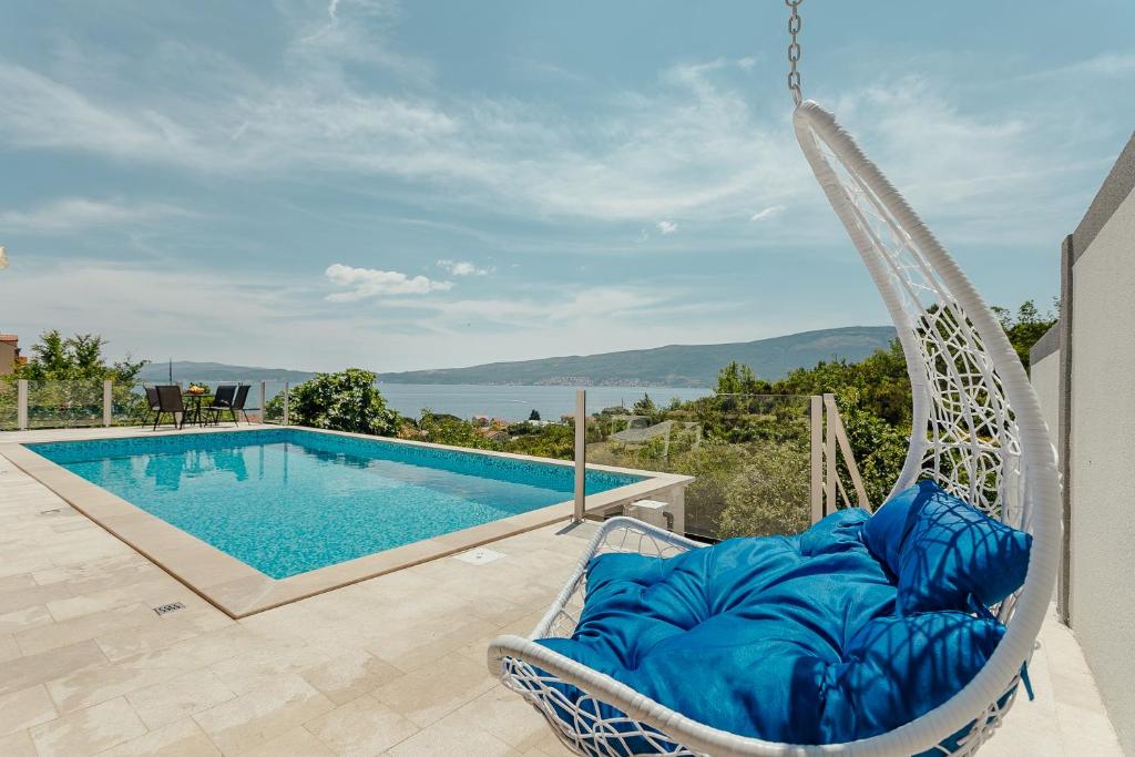 Villa Mediterano في هرسك نوفي: كرسي يتأرجح بجوار حمام السباحة