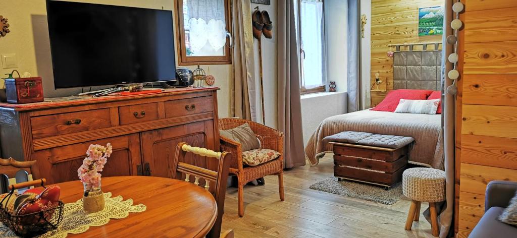 una sala de estar con TV en un tocador de madera en La grange de Lina, en Grignon
