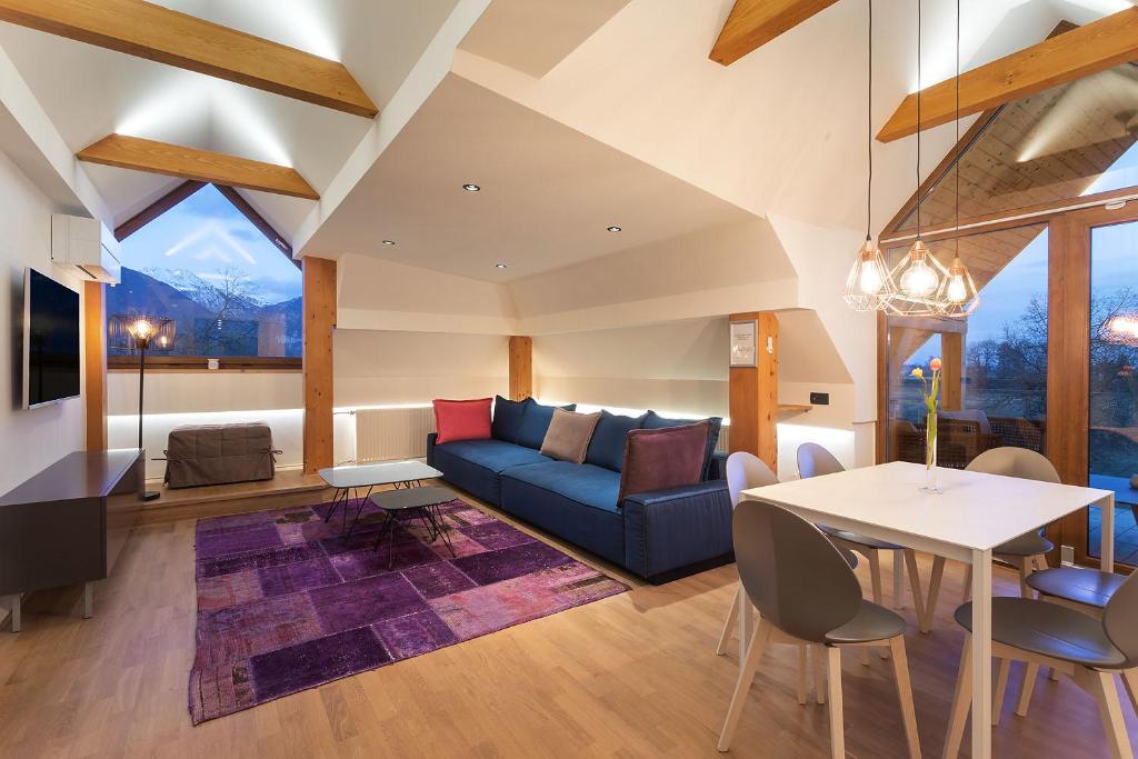 uma sala de estar com um sofá azul e uma mesa em Apartment Wellness Essense em Bled