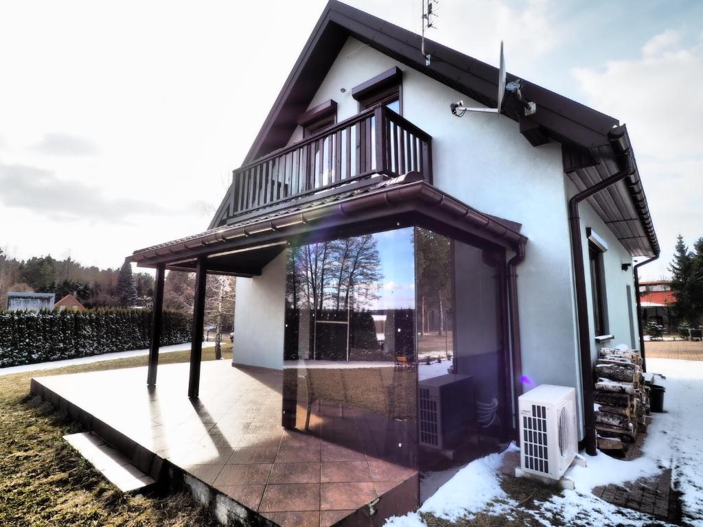 a small house with a balcony on a patio at Horyzont Wałpusz in Szczytno