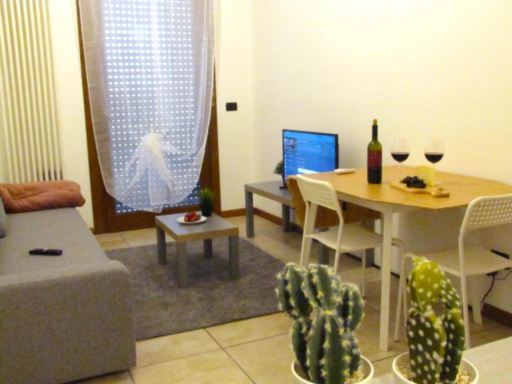 a living room with a table and a couch and a table with wine glasses at Vicenza City Apartments 2 in Vicenza