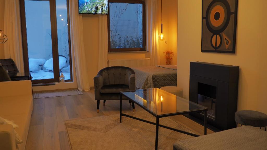 a living room with a fireplace and a room with a bed at Seasons Sunrise Studio - nature & view in Braşov