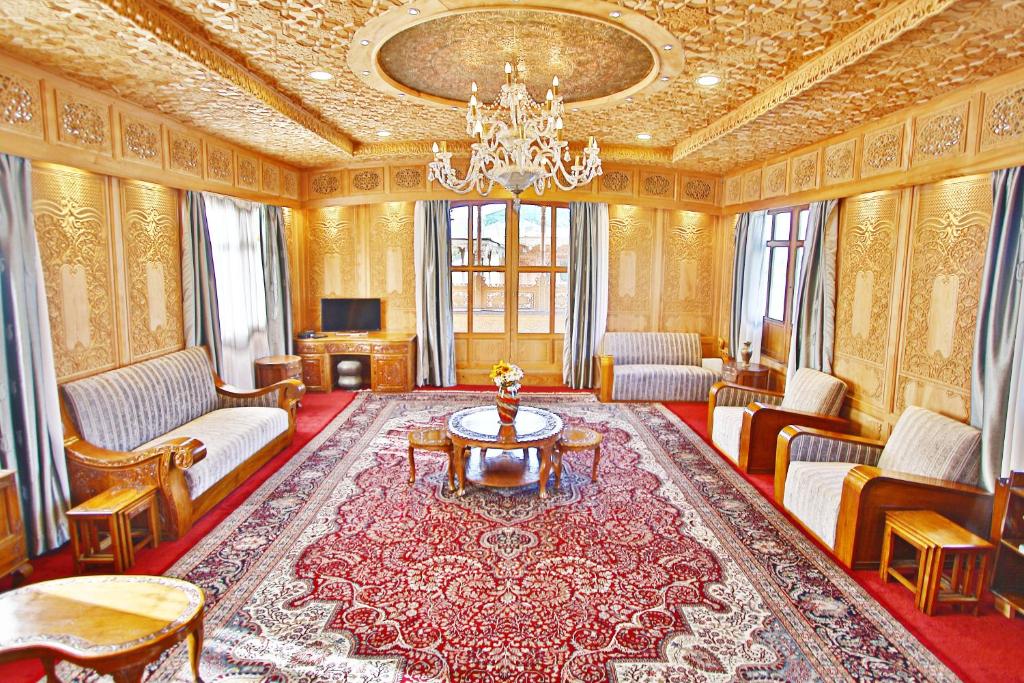 a living room filled with furniture and a chandelier at Mascot Houseboats in Srinagar