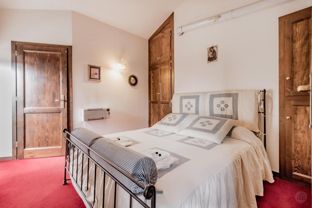 um quarto com uma grande cama branca e um tapete vermelho em Il Dolce Rifugio. Piazza principale di Leonessa em Leonessa