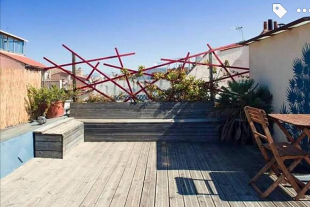 a patio with a wooden deck with a table and chairs at Studio 11 Panier Vieux Port Roof Top in Marseille