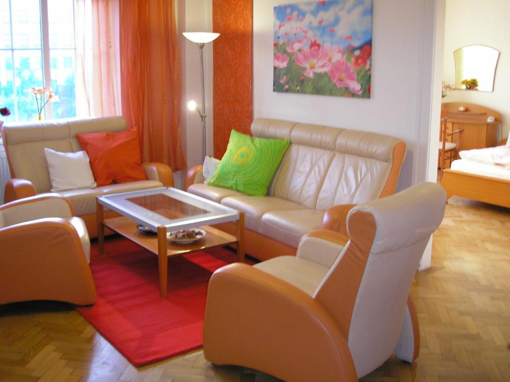een woonkamer met een bank, stoelen en een tafel bij Apartment Accommodation up to 17 in Bratislava