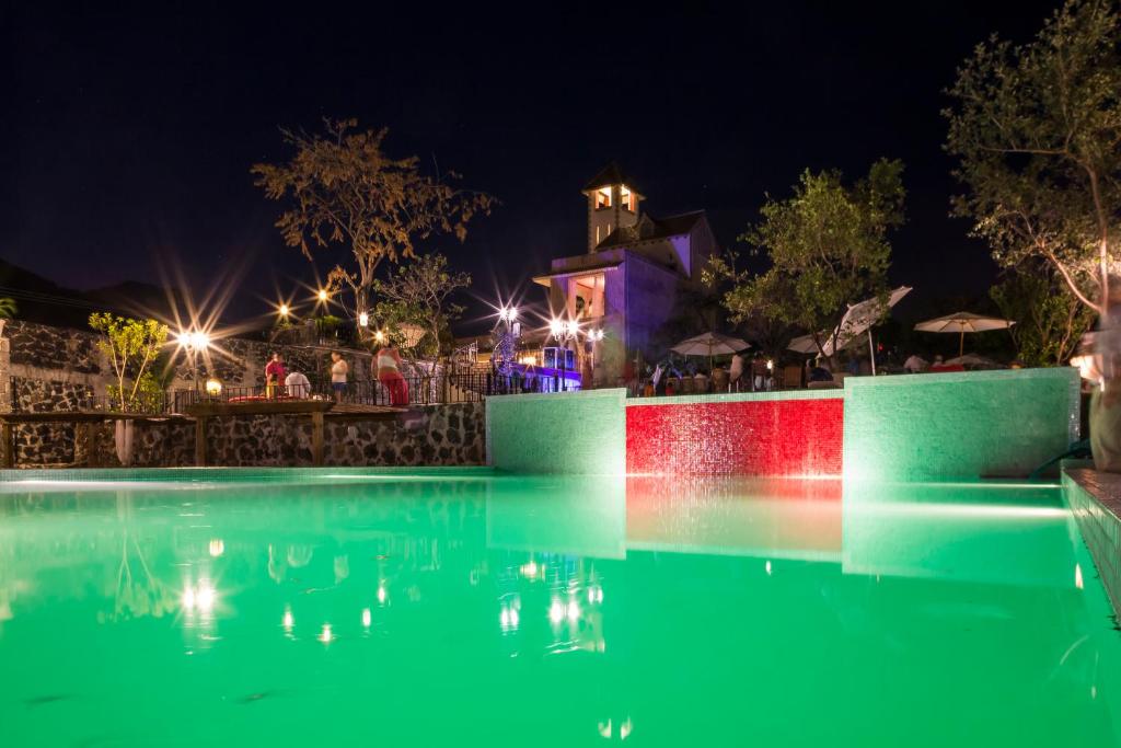 een zwembad 's nachts met lichten in het water bij Hotel Boutique Casa Isabella in Tepoztlán