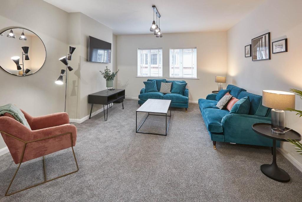 a living room with a blue couch and chairs at Host & Stay - Endeavour Apartments in Whitby
