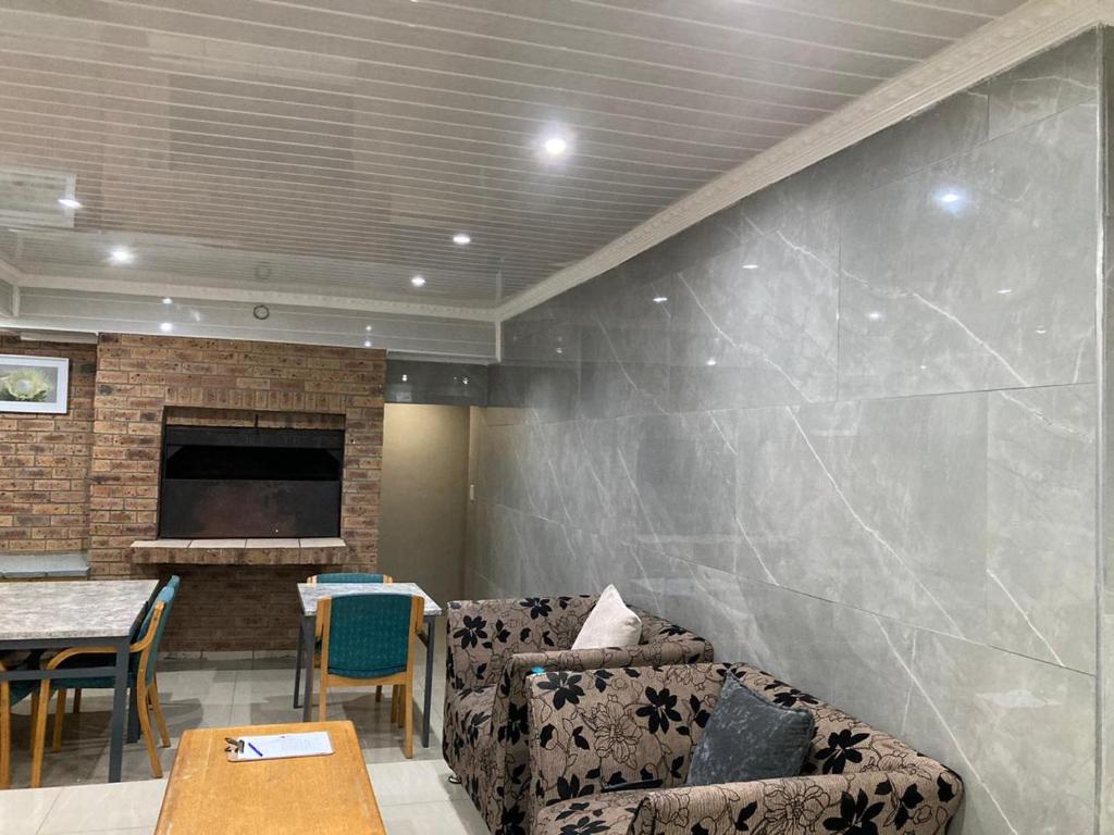 a living room with a couch and a fireplace at Hirondelle @ 45 Old Paarl in Bellville