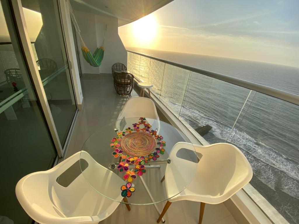 una mesa y 2 sillas en un balcón con vistas al océano en Caminando hacia la playa, en Cartagena de Indias