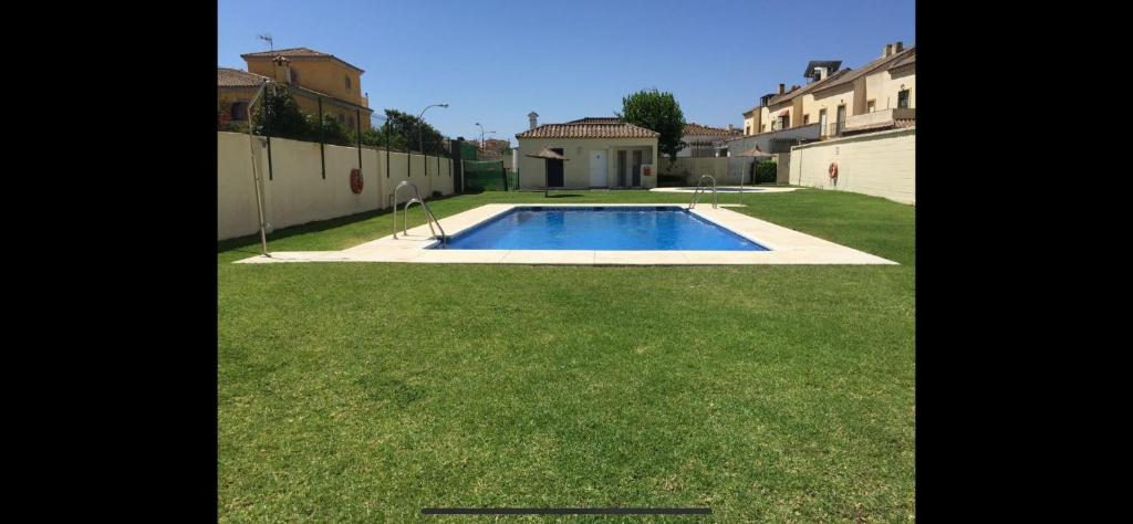 un patio trasero con una piscina en el césped en Apartamento en zona playa con vistas a la bahía, en Algeciras
