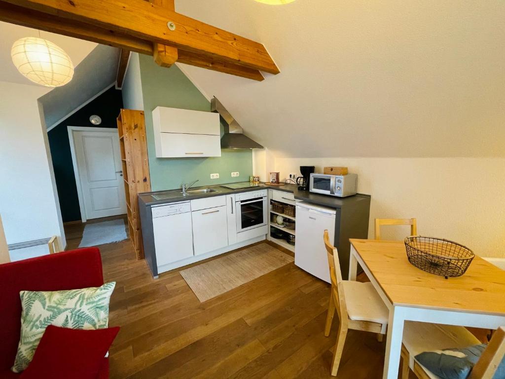 una cocina con armarios blancos y una mesa con comedor. en Ferienwohnung „Klein aber fein“ en Urbar