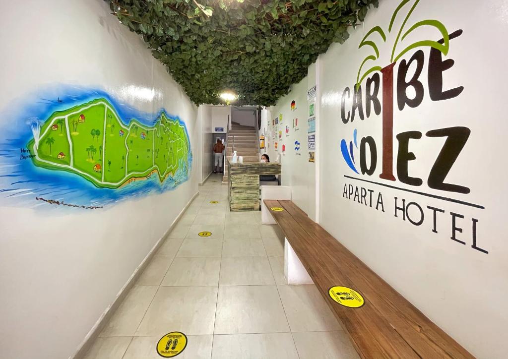 Apartahotel Caribe Diez في سان أندريس: غرفة مع مقعد وعلامة على الحائط