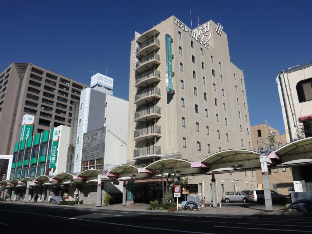 a large building on a city street with buildings at Kuretake-Inn Central Hamamatsu in Hamamatsu