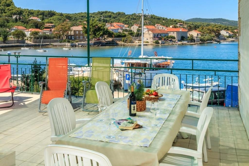 einen Tisch und Stühle auf einem Balkon mit Blick auf das Wasser in der Unterkunft Holiday home Linda2 - 20m from the sea in Lumbarda