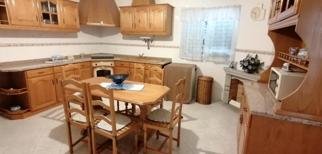 une cuisine avec une table en bois et une petite table et des chaises dans l'établissement Giravillage, à Girabolhos