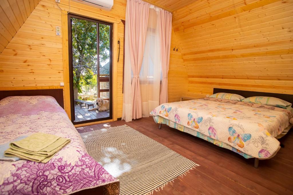 1 dormitorio con 2 camas y ventana en Ретритный центр "Дом Души" en Novy Afon