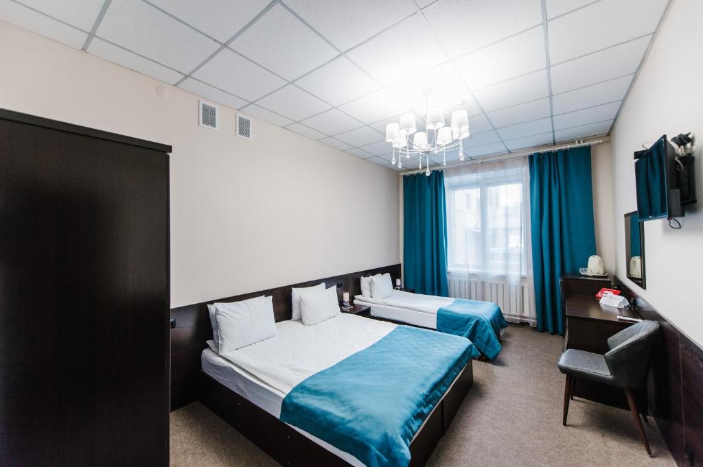 une chambre d'hôtel avec deux lits et une chaise dans l'établissement Hotel Dekabrist, à Chita