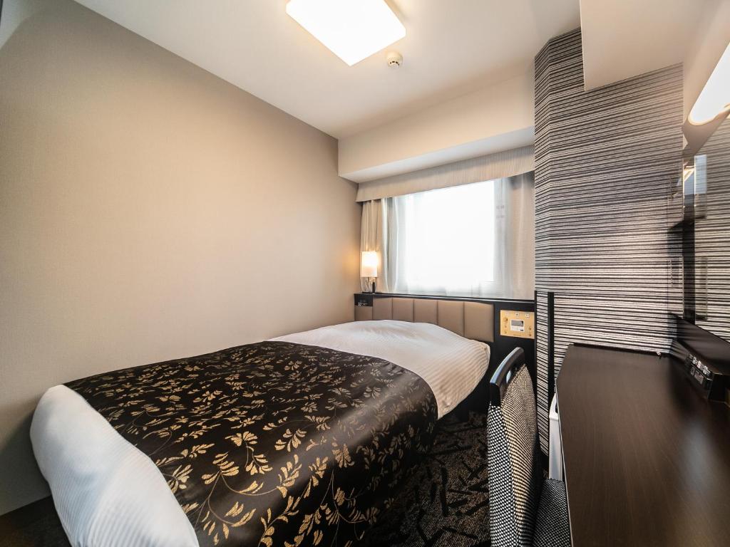 Postel nebo postele na pokoji v ubytování APA Hotel Osaka Temmabashi Ekimae