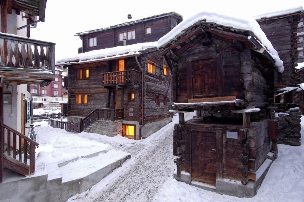 una baita di tronchi nella neve con la neve di Ferienapartement Hinterdorf a Zermatt