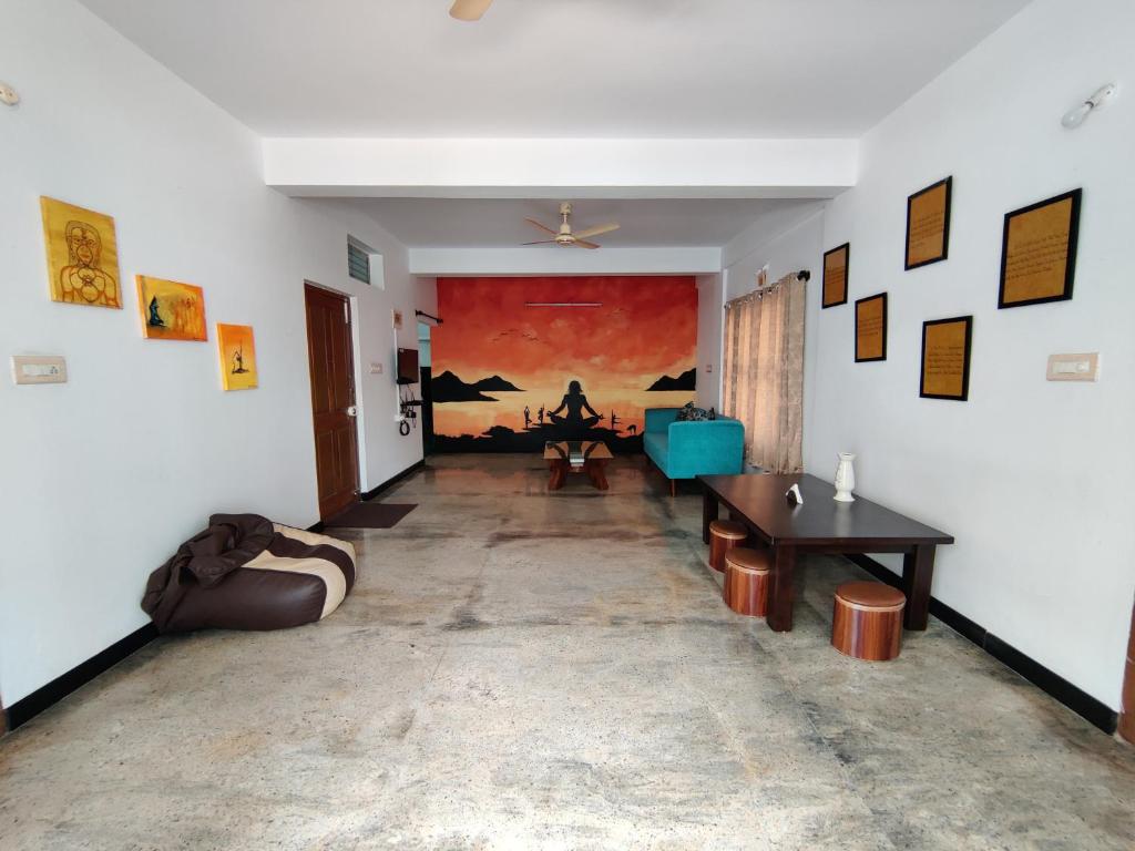 una sala de estar con una gran pintura en la pared en Yoga House, en Vānivilāsa Puram