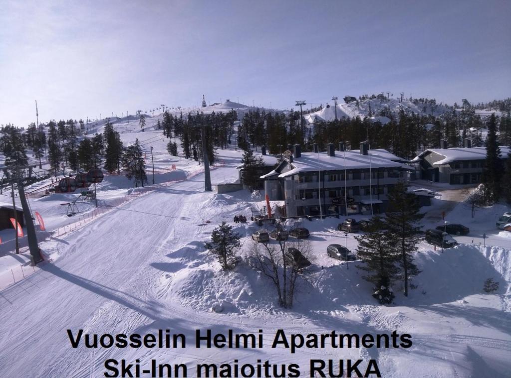 a ski resort in the snow with a building at Vuosselin Helmi Apartments in Ruka