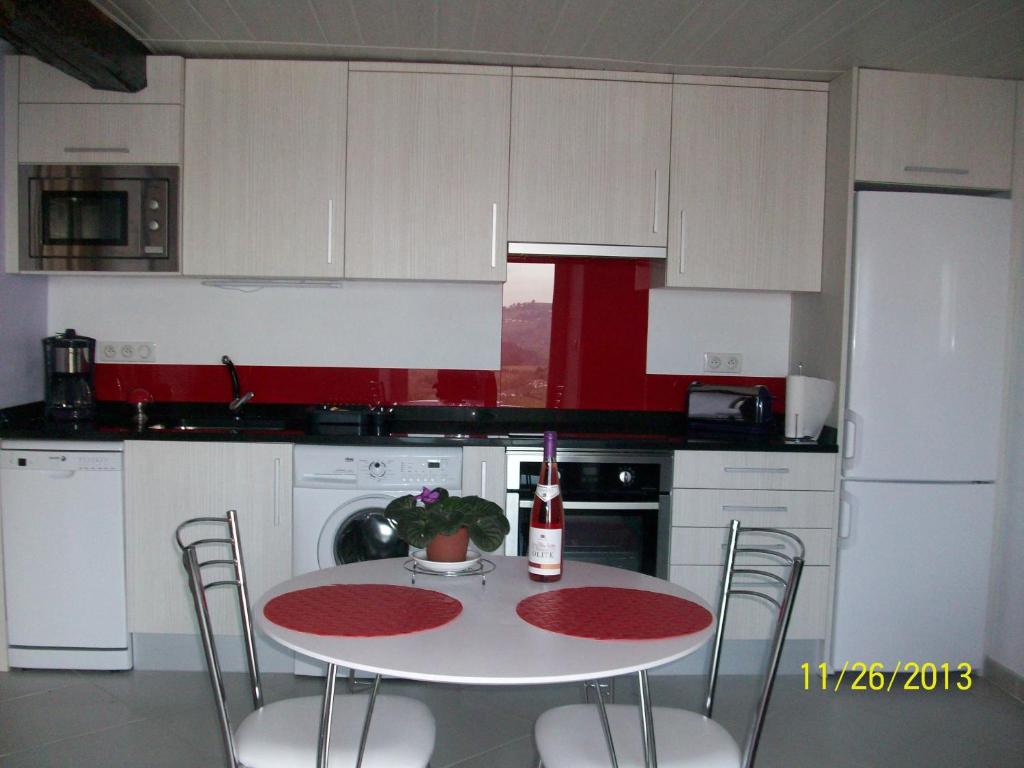 a kitchen with a table and chairs and a refrigerator at Appartement Larraburuko-Borda in Sare