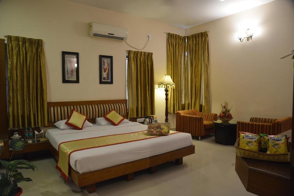 a hotel room with two beds and a living room at Pai Vista, KR Road in Bangalore