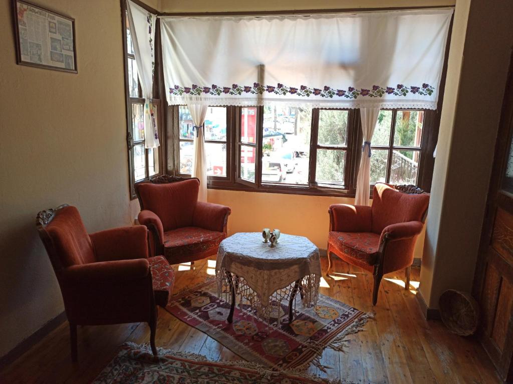 a living room with chairs and a table and windows at Bayraktar Konağı City Center in Demre