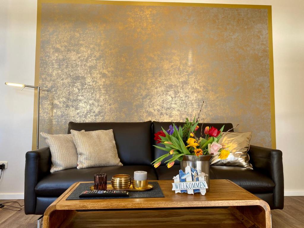 a black leather couch in a living room with a coffee table at Villa Anna - Kaiserperle in Heringsdorf