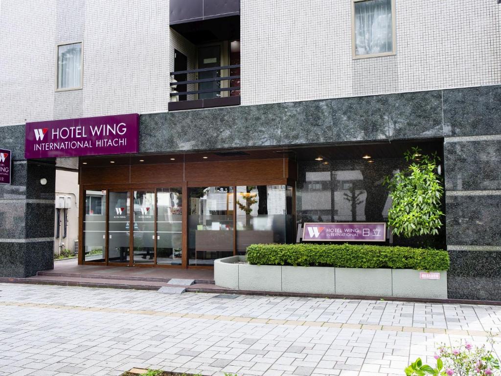 un edificio con un cartello di fronte di Hotel Wing International Hitachi a Hitachi